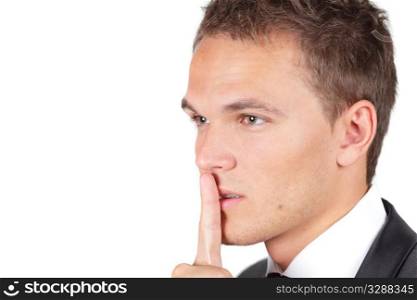 Portrait of businessman showing silence gesture with his forefinger by mouth looking asiade. Portrait of businessman showing silence gesture with his forefinger by mouth looking aside
