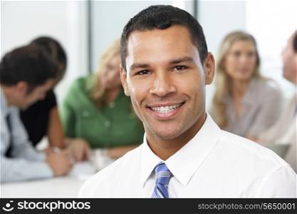 Portrait Of Businessman Sitting At Boardroom Table
