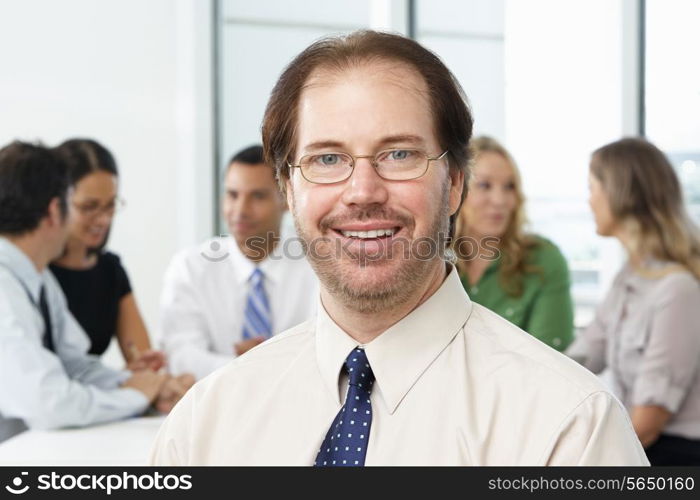 Portrait Of Businessman Sitting At Boardroom Table