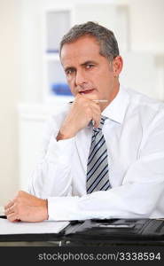 Portrait of businessman sitting at his desk