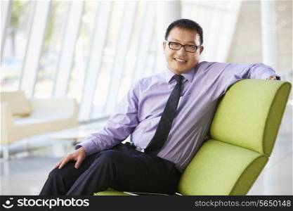 Portrait Of Businessman Sitting On Sofa In Modern Office