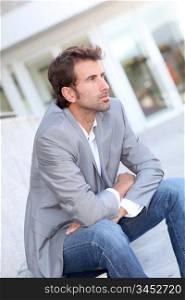 Portrait of businessman sitting outside in the street
