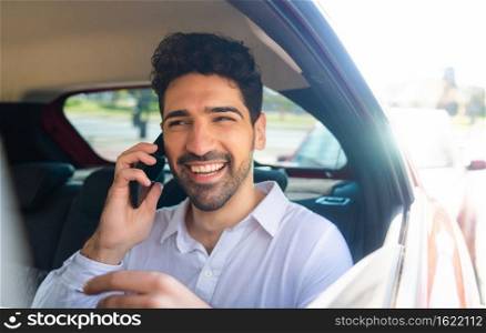 Portrait of businessman talking on phone on way to work in a car. Business concept. 
