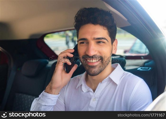 Portrait of businessman talking on phone on way to work in a car. Business concept.