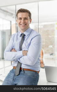 Portrait of businessman with arms crossed in office