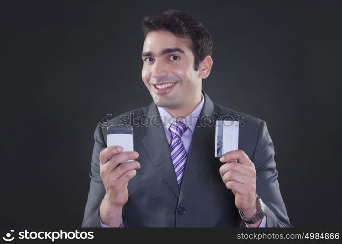 Portrait of businessman with mobile phone and credit card