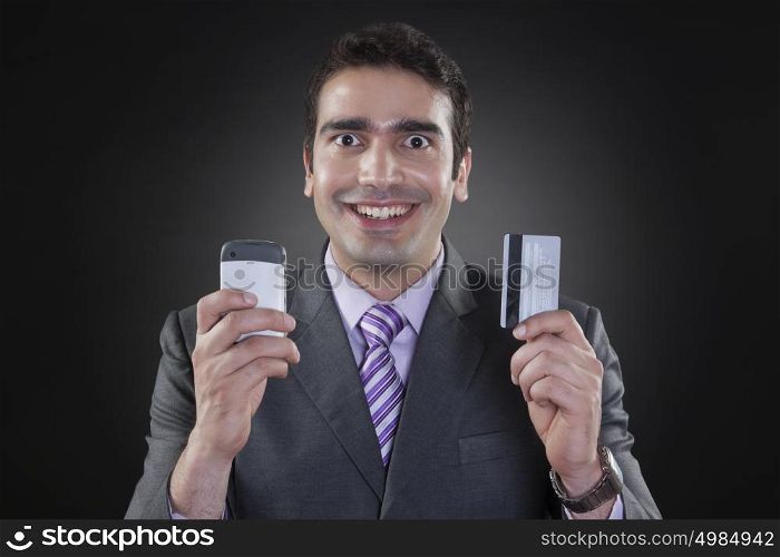 Portrait of businessman with mobile phone and credit card