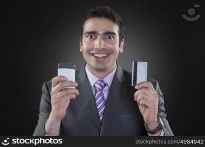 Portrait of businessman with mobile phone and credit card