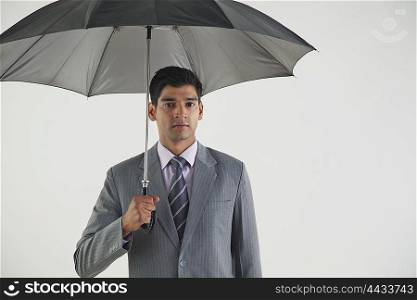 Portrait of businessman with umbrella