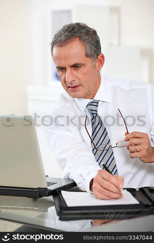 Portrait of businessman working on laptop computer