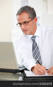 Portrait of businessman working on laptop computer