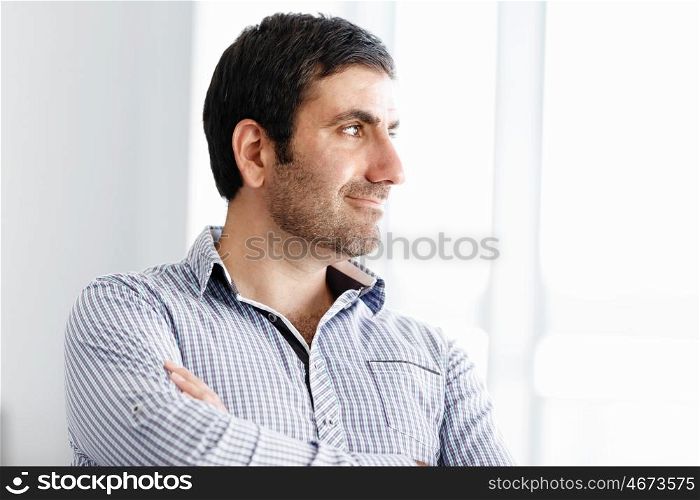 Portrait of businessman. Young businessman standing in offfice with arms crossed