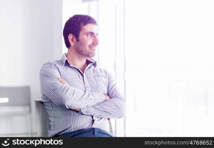 Portrait of businessman. Young businessman standing in offfice with arms crossed