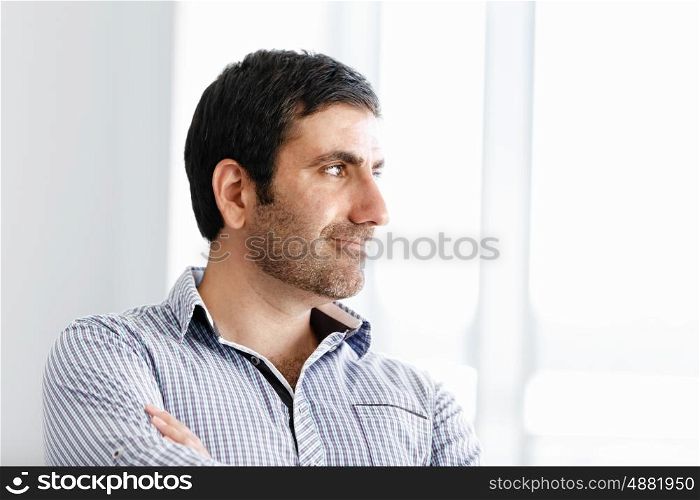 Portrait of businessman. Young businessman standing in offfice with arms crossed