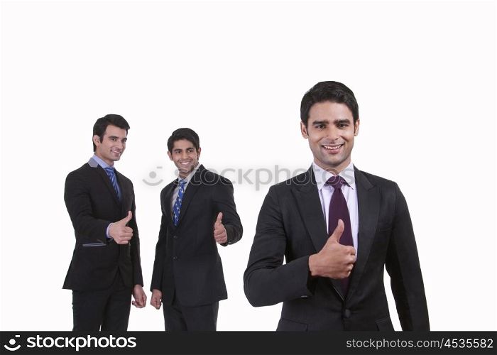 Portrait of businessmen giving thumbs up