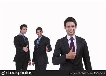 Portrait of businessmen giving thumbs up