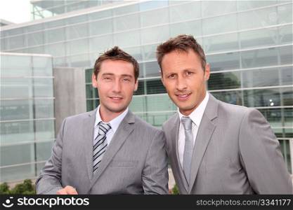 Portrait of businessmen standing in front of modern building