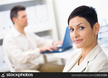 Portrait of businesswoman at office, smiling.