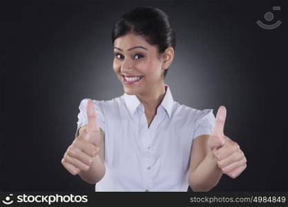 Portrait of businesswoman giving thumbs up