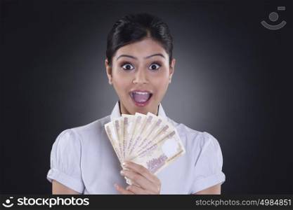 Portrait of businesswoman holding currency