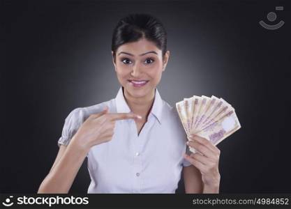 Portrait of businesswoman holding currency