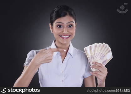 Portrait of businesswoman holding currency