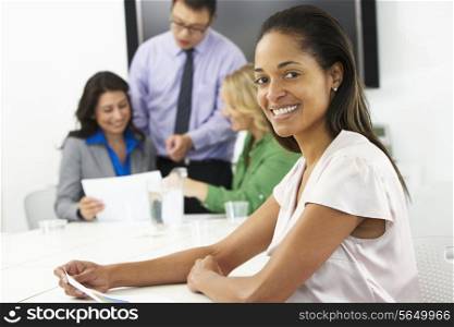 Portrait Of Businesswoman In Boardroom With Colleagues