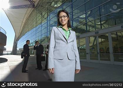 Portrait of businesswoman in front of office building