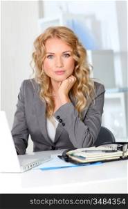 Portrait of businesswoman in office working on laptop computer