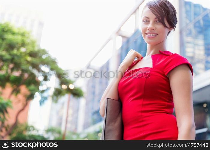Portrait of businesswoman outside. Portrait of beautiful business woman in red dress