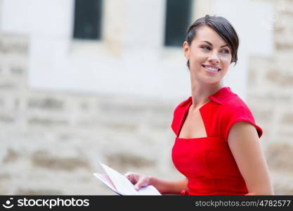 Portrait of businesswoman outside. Portrait of business woman in sitting outside and holding papers