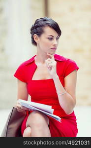 Portrait of businesswoman outside. Portrait of business woman in sitting outside and holding papers