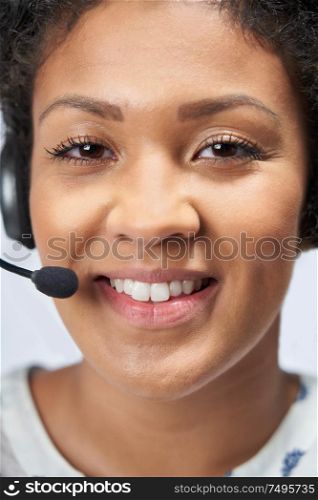 Portrait Of Businesswoman Wearing Telephone Headset In Customer Services Department