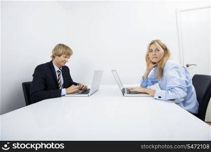 Portrait of businesswoman with coworker working in office