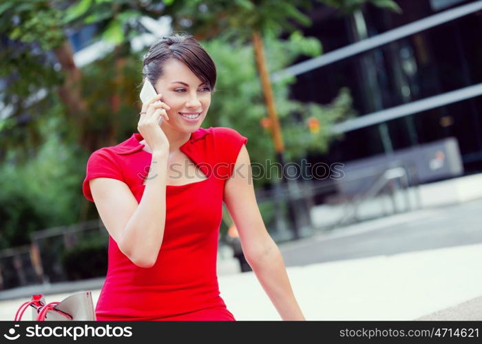 Portrait of businesswoman with mobile phone. Portrait of beautiful business woman in red dress holding her mobile