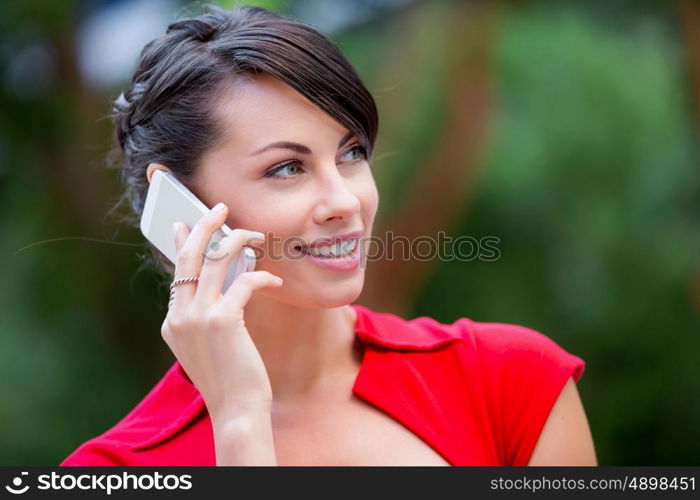 Portrait of businesswoman with mobile phone. Portrait of beautiful business woman in red dress holding her mobile