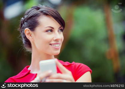 Portrait of businesswoman with mobile phone. Portrait of beautiful business woman in red dress holding her mobile