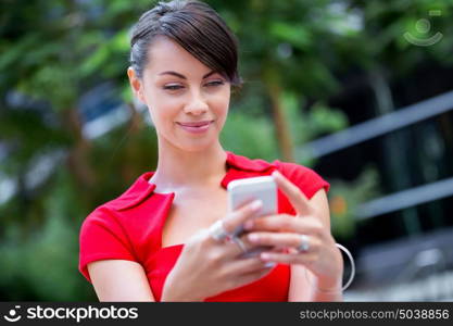 Portrait of businesswoman with mobile phone. Portrait of beautiful business woman in red dress holding her mobile