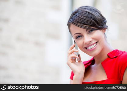 Portrait of businesswoman with mobile phone. Portrait of beautiful business woman in red dress holding her mobile