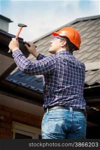 Portrait of carpenter at work repairing house roof
