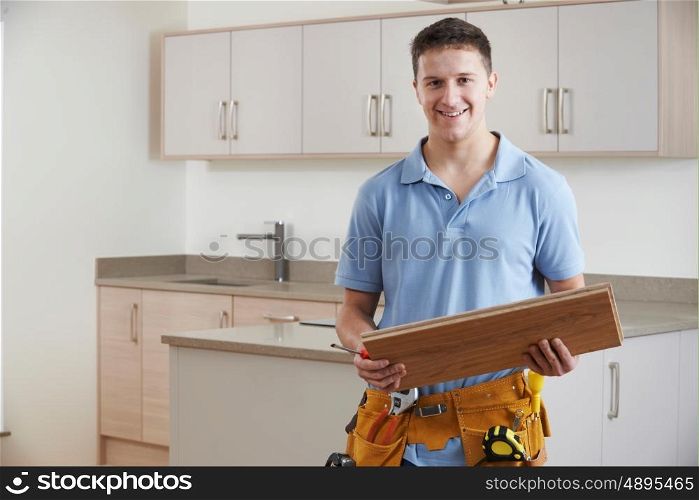 Portrait Of Carpenter Installing Fitted Kitchen