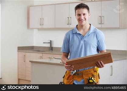 Portrait Of Carpenter Installing Fitted Kitchen