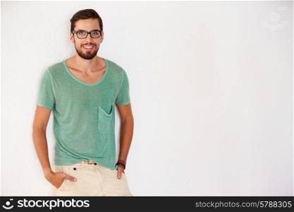 Portrait Of Casually Dressed Man Leaning Against White Wall