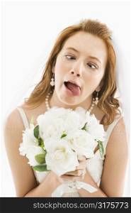 Portrait of Caucasian bride holding bouquet and making funny face.