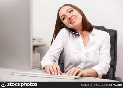 Portrait of caucasian brunette businesswoman phoning at her desk in office