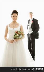 Portrait of Caucasian groom and Asian bride.