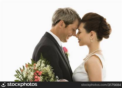 Portrait of Caucasian groom and Asian bride embracing