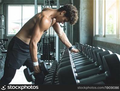 Portrait of Caucasian handsome muscular man doing exercise in gym. Sport Concept.