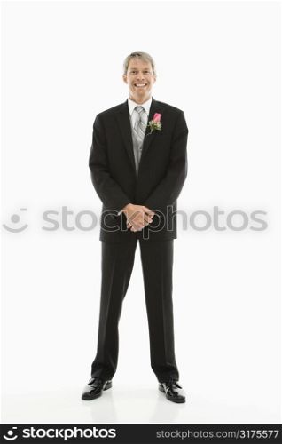 Portrait of Caucasian male in tuxedo with boutonniere.