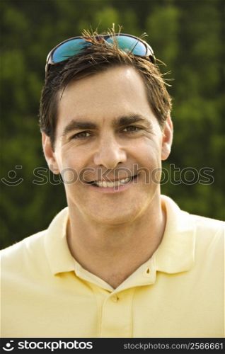 Portrait of Caucasian mid-adult man smiling at camera.